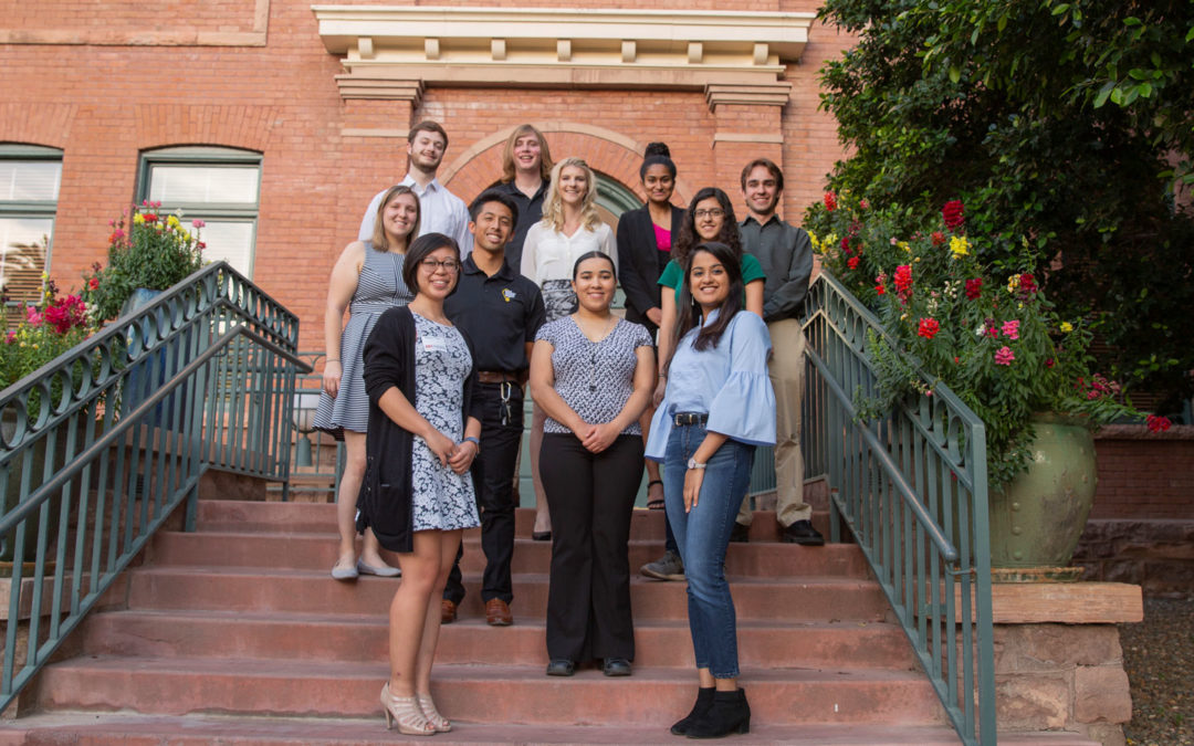 13 Grand Challenge Scholars stand on the steps of a building at ASU