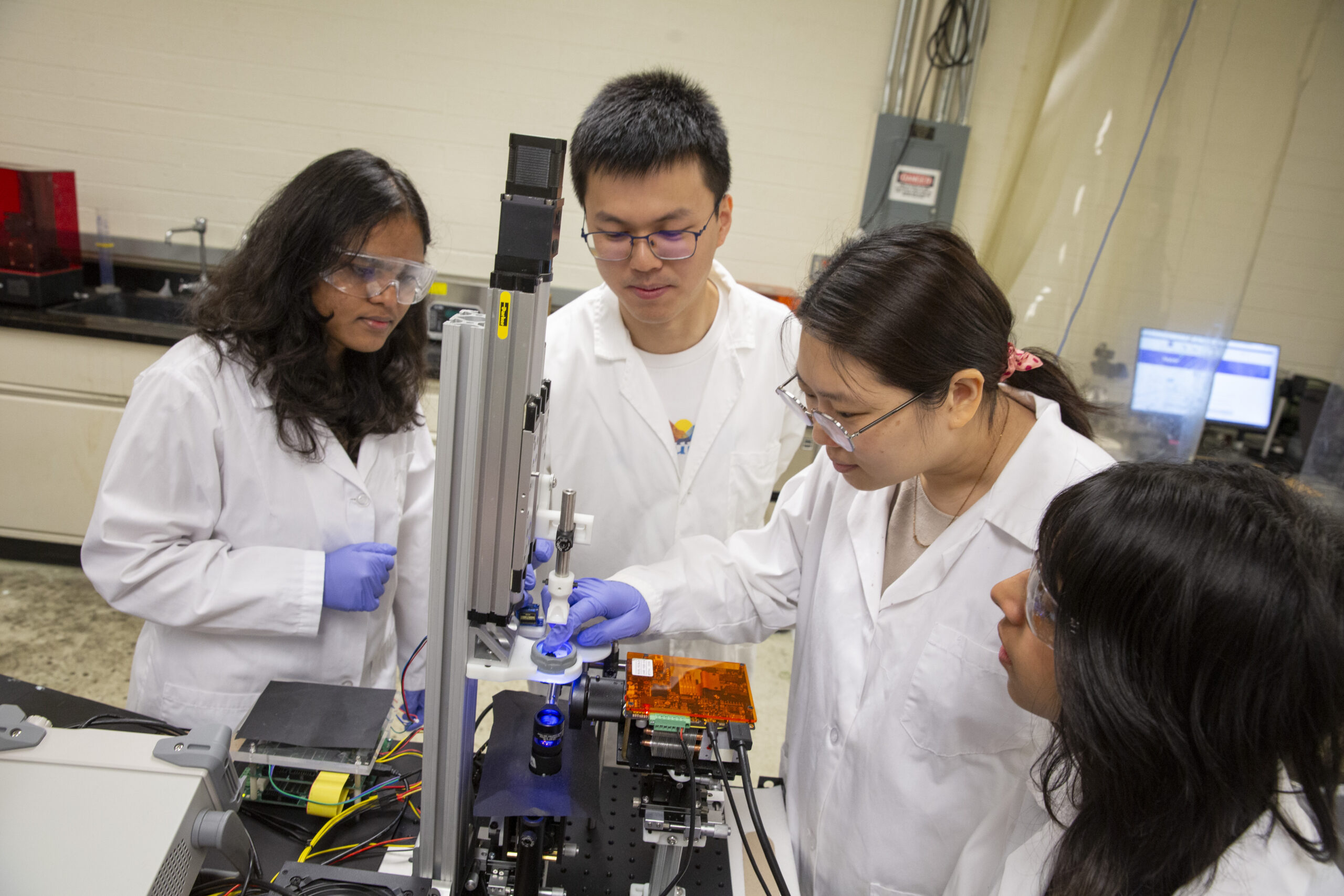  Xiangjia “Cindy” Li (second from right), an assistant professor of aerospace and mechanical engineering in the Ira A. Fulton Schools of Engineering at Arizona State University, in her lab with three of her students. Li received a 2024 National Science Foundation Faculty Early Career Development Program (CAREER) Award for developing a novel approach to printing 3D products with complex designs using both metal and polymer materials. Photographer: Erika Gronek/ASU