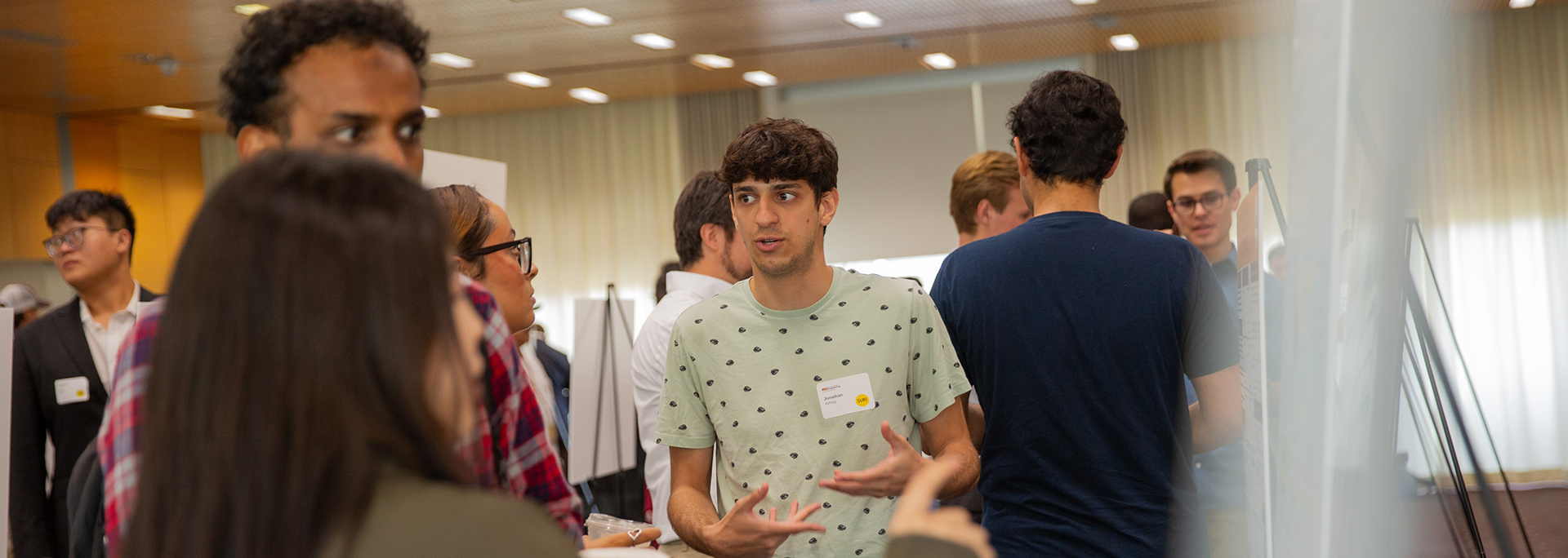 An ASU student explaining his research at a Summer Research Initiative event