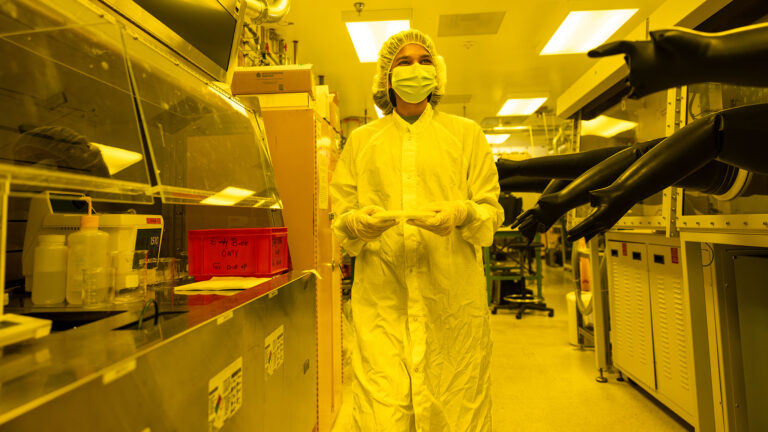ASU electrical engineering master’s student Shreenidhi Anand walks through a cleanroom holding a wafer at MacroTechnology Works. Photographer: Samantha Chow/ASU